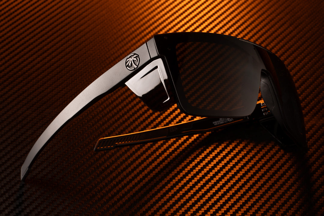 Lying on its side is the Heat Wave Visual Performance Quatro Ultra Black Sunglasses.