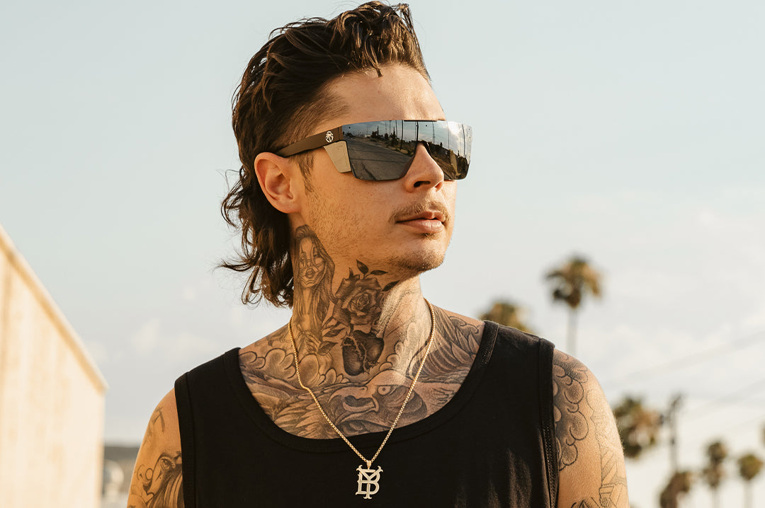 Young dude with tattoos rocking the Heat Wave Visual Performance Quatro Sunglasses with black frame, silver lens and matching colored side shields.