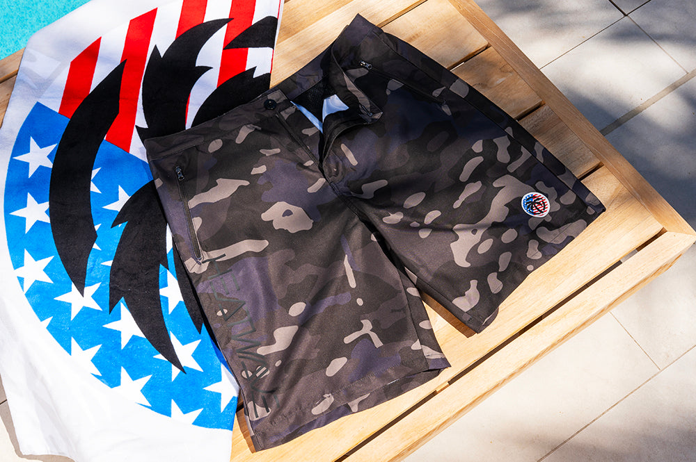 Lying on a beach chair is the Heat Wave Visual Midnight Camo Board Shorts. 